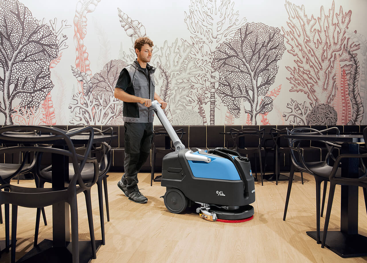 Man Cleaning Cafe Floor With Floor Spinning Machine
